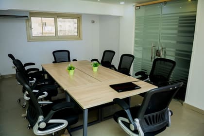 Boardroom at Blooms set for ten with a timber table and glass partition