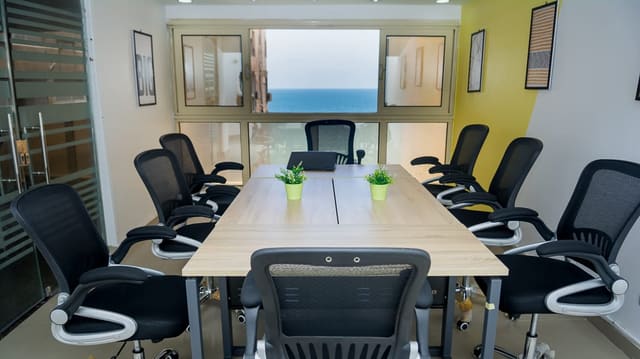 Ten-seat conference room at Blooms with a window framing the Mediterranean