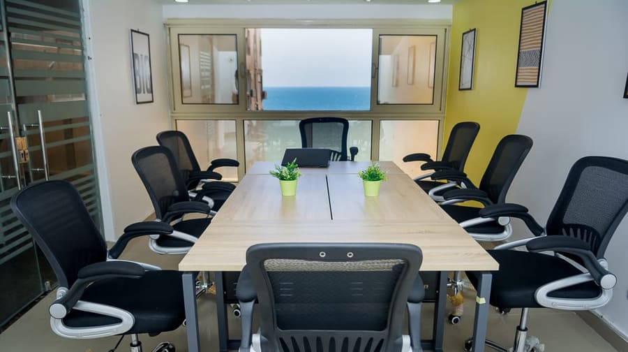 Ten-seat conference room at Blooms with a window framing the Mediterranean
