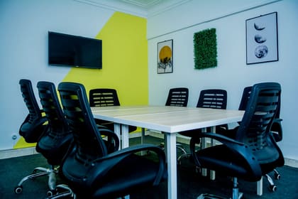 Meeting room at Blooms with a wall display, preserved moss panel and eight seats