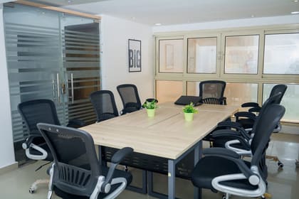 Glass-walled meeting room at Blooms with daylight along the window bay