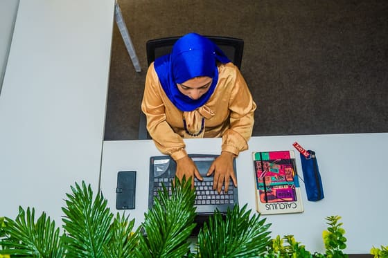 Overhead view of a member typing at a tidy white desk at Blooms