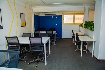 Daylit private office at Blooms with white desks and framed artwork