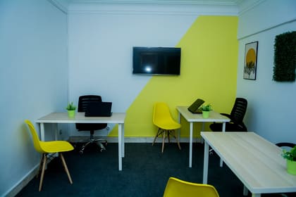 Private office at Blooms with a wall-mounted display, desk and ergonomic seating