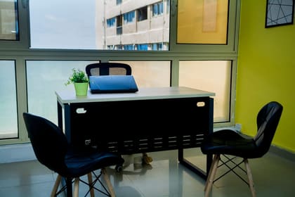 Private office desk at Blooms beside a window with a sea view over Alexandria