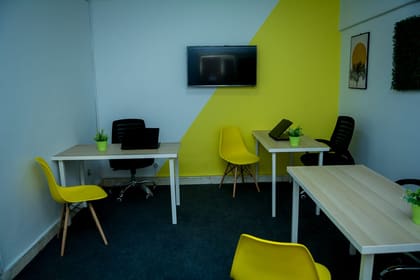A furnished private office suite at Blooms with desks, a wall display and a lime accent wall