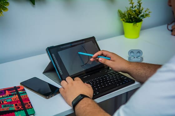 A member sketching on a graphics tablet with a stylus at their desk at Blooms